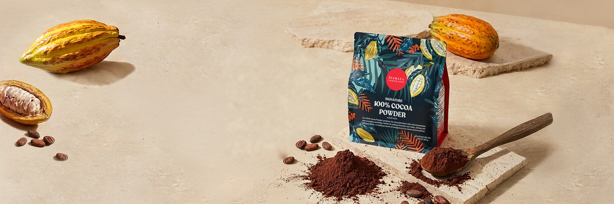 Siamaya 100% Cocoa Powder pouch with cacao pods, cocoa powder and a wooden spoon.