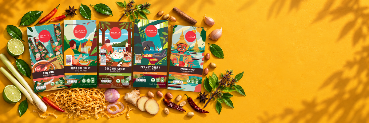 Five Siamaya Thai curry chocolate bars with spices and ingredients on a saffron tabletop