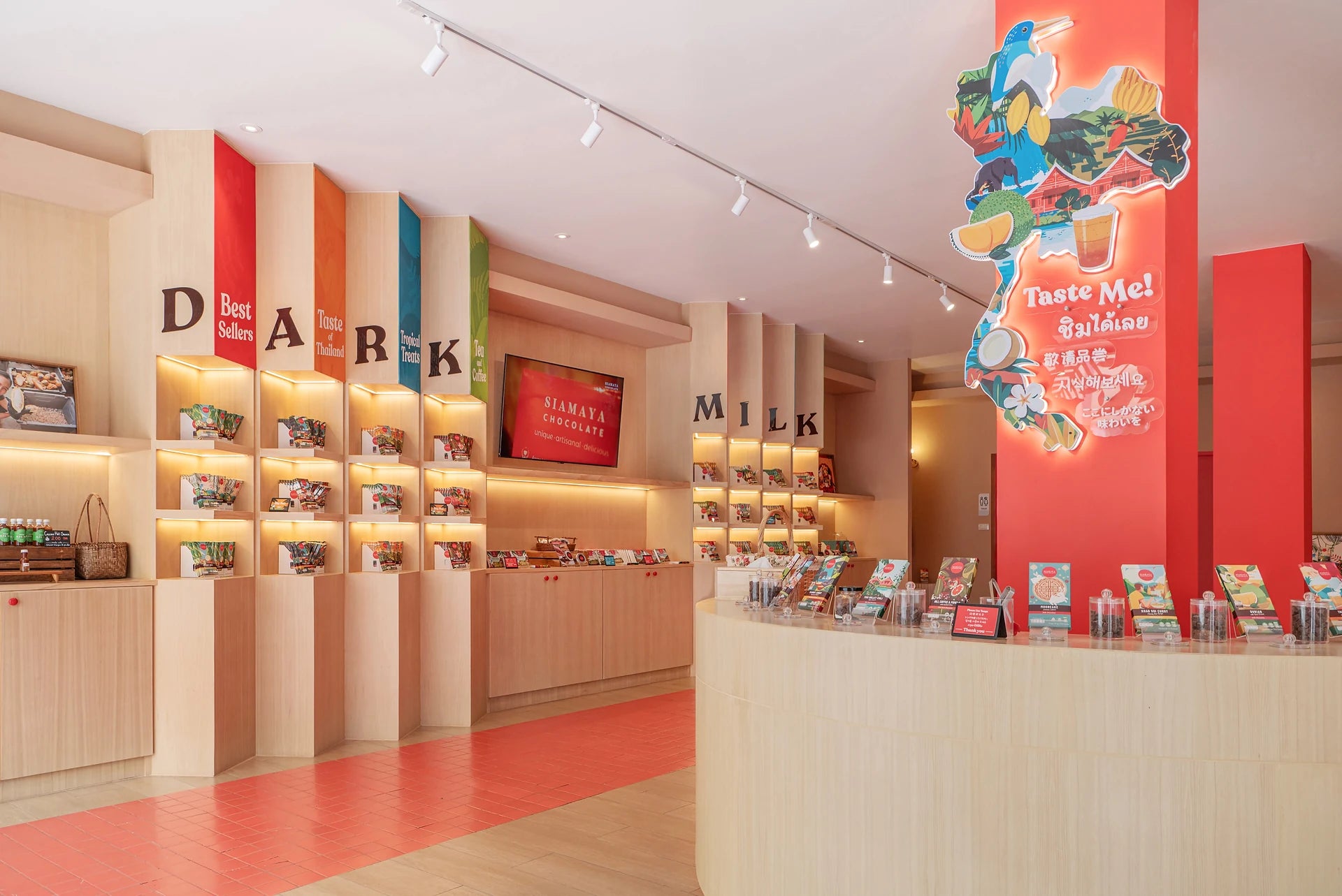 Warm wood displays and colorful chocolate shelves inside Siamaya’s Thapae shop
